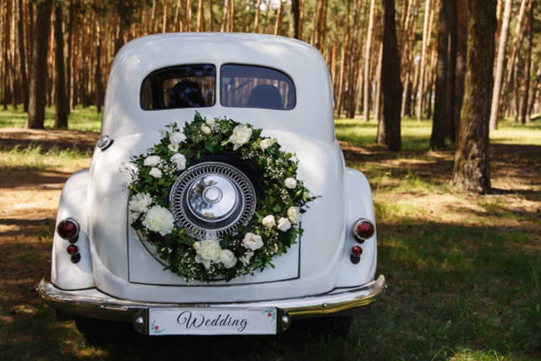 White car with wreath of flowers on the spare tyre