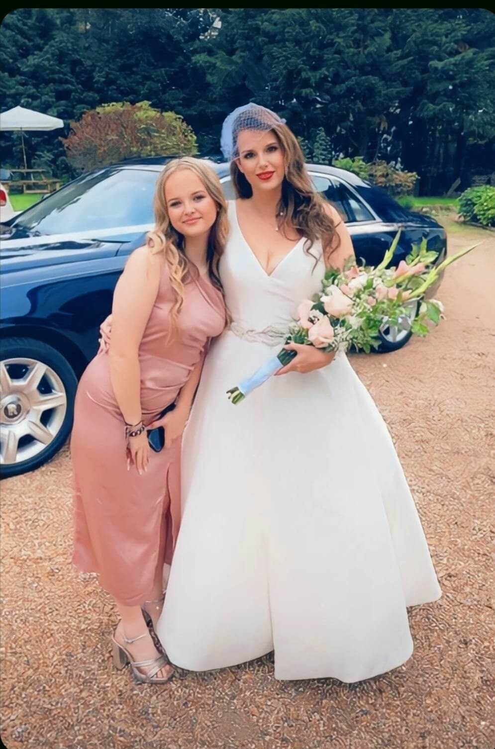 bride with bridesmaid holding flowers